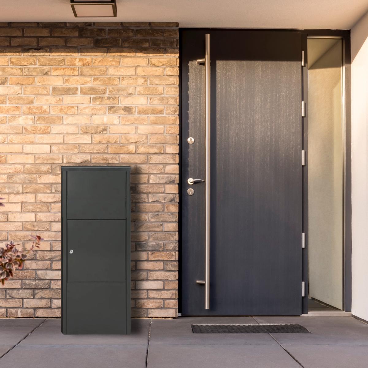 De pakketbrievenbus Bremen in mat zwart van het merk Practo Garden en verkoper BUY A BOX naast de voordeur tegen de muur van een modern huis.